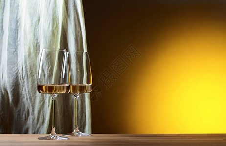 黄色背景的白葡萄酒镜图片