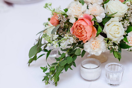 美丽的鲜花绿花和小玻璃烛台婚礼桌上背景图片