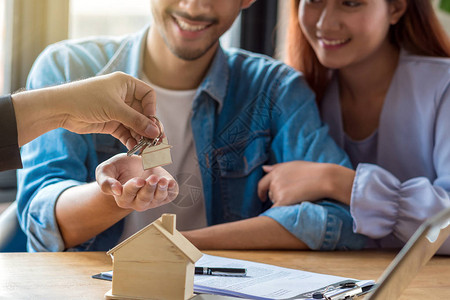 销售代表上的特写房屋模型在新地方的工作空间桌上提供房屋价格表和购买或租赁条件搬背景图片