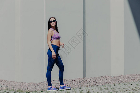 穿着紫色上衣打底裤和运动鞋的女运动员图片