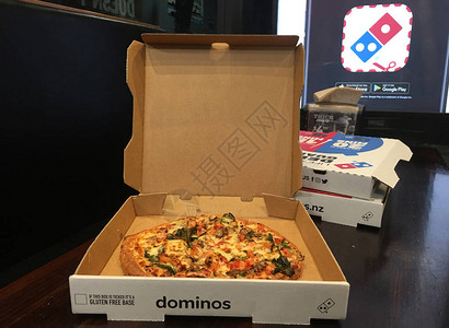 在桌子上的外卖盒中打开DominosPizza成立于1960年图片