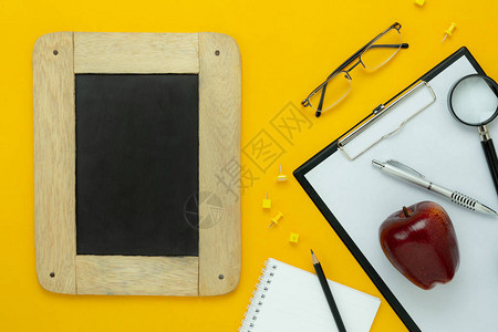 回到学校教育季节背景概念的桌面视图空中图像平躺配件黑板与现代质朴的黄色纸上的纸夹板设计模背景图片