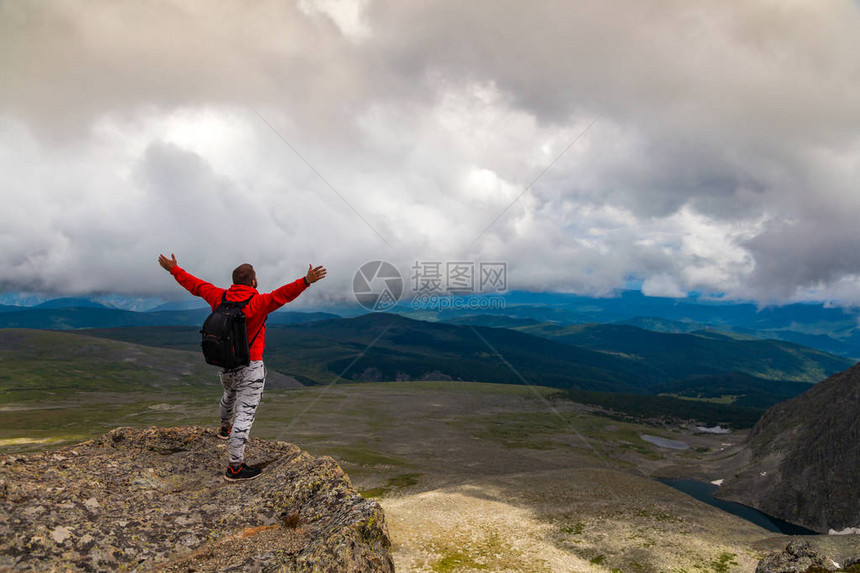 男子徒步旅行者欣赏日落山峰悬崖的景色高山时尚男子徒步旅行的摄影师旅行者旅行生活方式和生图片