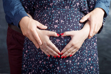 孕妇及其丈夫用手抚摸怀孕肚子图片