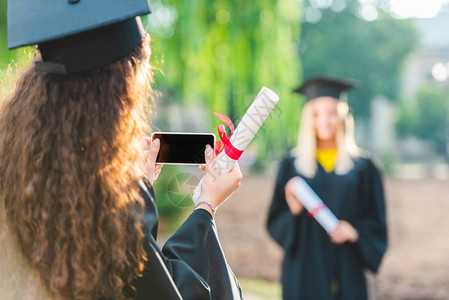 女生在大学毕业时以智能手机拍摄同班学片段照片的观感图片