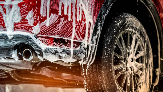 带有运动和现代设计的红色紧凑型SUV车用肥皂清洗用白色泡沫盖的汽车汽车护理服务经营理念玻璃打蜡和玻璃涂层汽车背景图片