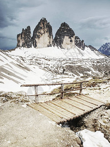 在意大利多洛米蒂山脉的徒步路径上的木扶手和标志TreCimediLa图片
