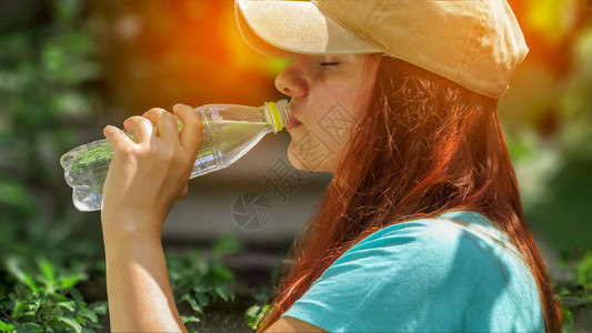 夏日阳光下的女人喝水图片