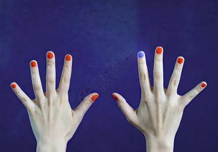 白种人手中指的一种不同指甲颜色红色和蓝色的指甲从人群中脱颖而出图片