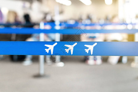 机场等候区大厅或休息室排队屏障上的飞机图标坐在背景中的乘客旅行和休图片