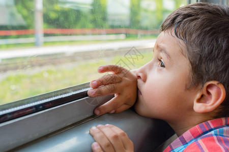 悲伤的男孩坐火车看着窗外图片