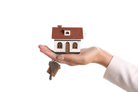 房地产经纪人持有房屋模型和白色背景钥匙的图片