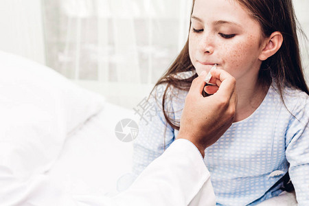 医生拿着温度计检查生病的小女孩生病的小女孩在床上图片