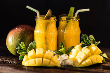 芒果汁和芒果加冰的木制桌底面恢复夏季饮料图片