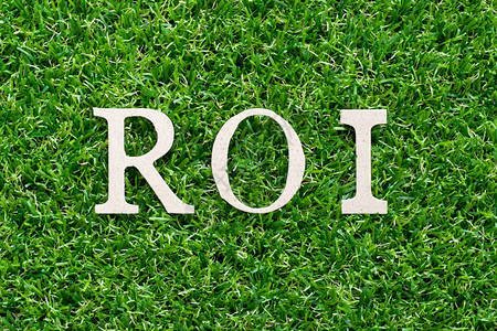 人工绿草背景的木材文字母ROI投资回报率图片