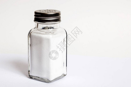 灰色背景上带盐的玻璃罐带阴影图片