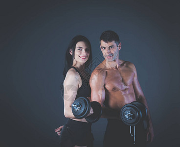 运动男人和女人用哑铃私人健身教练个人训练重图片