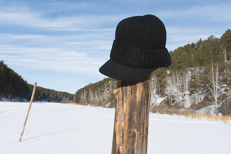 冬季在河边的杆子上丢掉的帽子图片