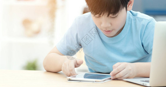 亚洲可爱的男孩在平板电脑上背景图片