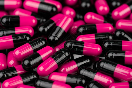 一堆粉黑色的胶囊丸抗生素耐药合理用药全球医疗保健概念抗生素耐药抗菌胶囊背景图片