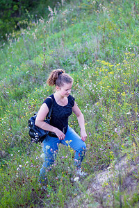 一个背着包的女孩上山主动休息自然为图片
