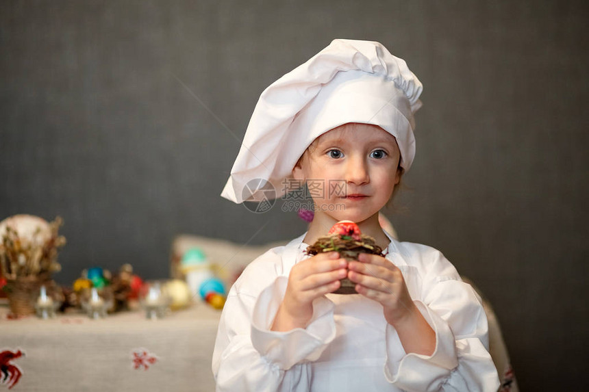 春天来了复活节前夕复活节彩蛋复活节彩蛋一个穿着厨师服的女孩画鸡蛋糕的烤图片
