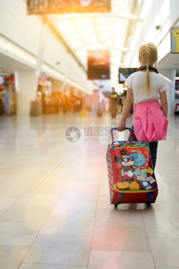 金发女孩带着行李从机场图片
