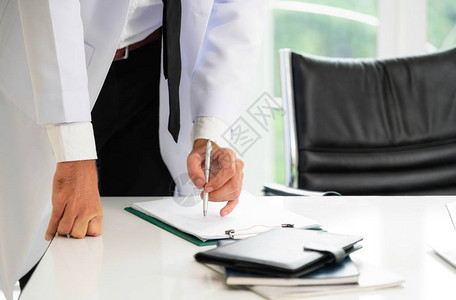 年轻男医生在医院的办公桌工作图片