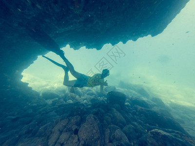男潜水员游过天然水下隧道探索海岸线图片