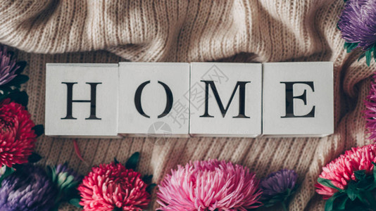 背景与温暖的毛衣和家的题字一堆带有秋花针织品秋春概背景图片