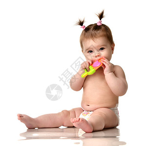 婴儿女孩蹒跚学步的孩子坐在绿色的牙齿胶上图片