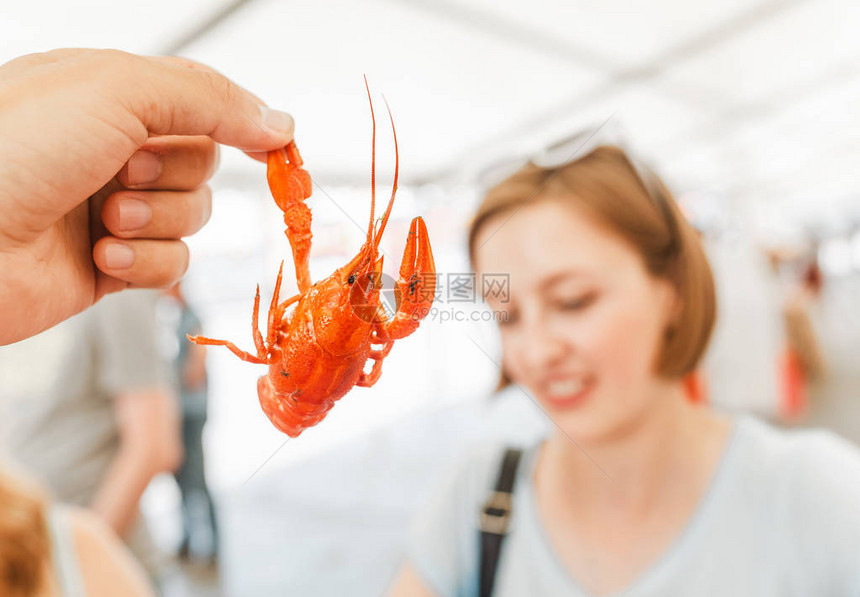 年轻妇女食用红锅煮的美味龙虾或龙虾图片