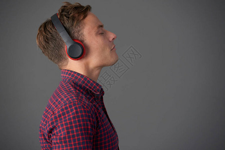戴耳机享受好音乐的年轻人背景图片