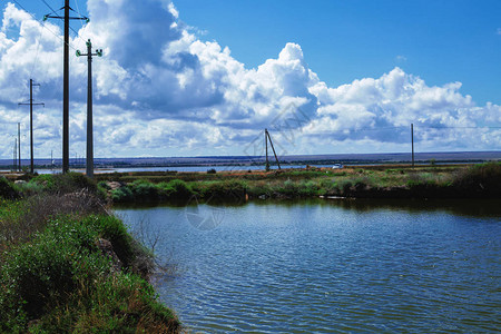 在青草岛与蓝天相对的绿色草地背景上的河流水面图片