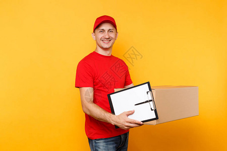 在黄色背景上孤立的红色制服的送货员身穿T恤帽的男员工信使拿着笔夹板图片