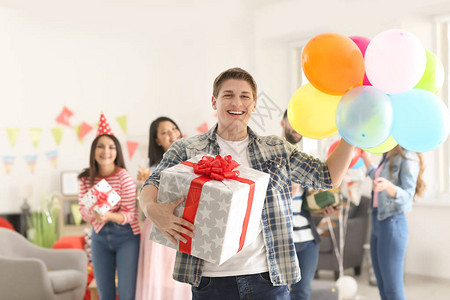 年轻人有礼物盒和气球在室内背景图片