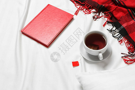 床单上的茶杯和笔记本图片