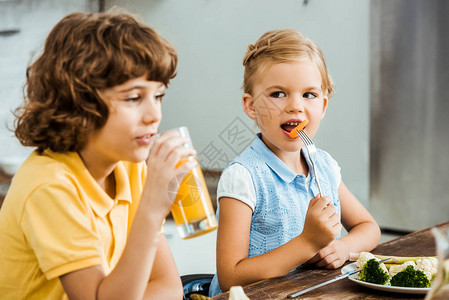 可爱的小孩吃蔬菜和喝图片