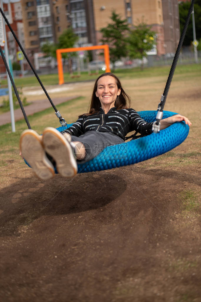 微笑的女孩躺在悬吊摇摆自由概念休息图片