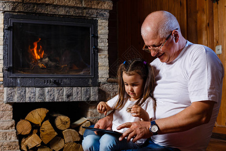 祖父和孙女在壁炉旁消磨时光背景图片