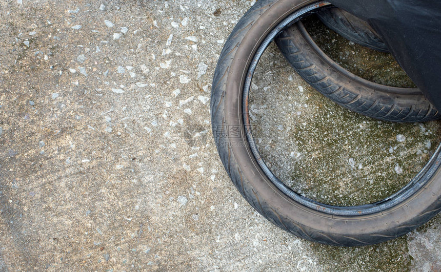 道路混凝土上的旧摩托车轮胎顶视图图片