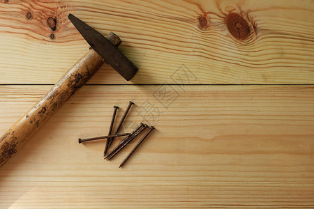 纹理木质背景上的旧锤子和钉子图片