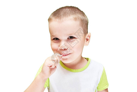 一个小男孩嘴里塞着糖果棍子图片
