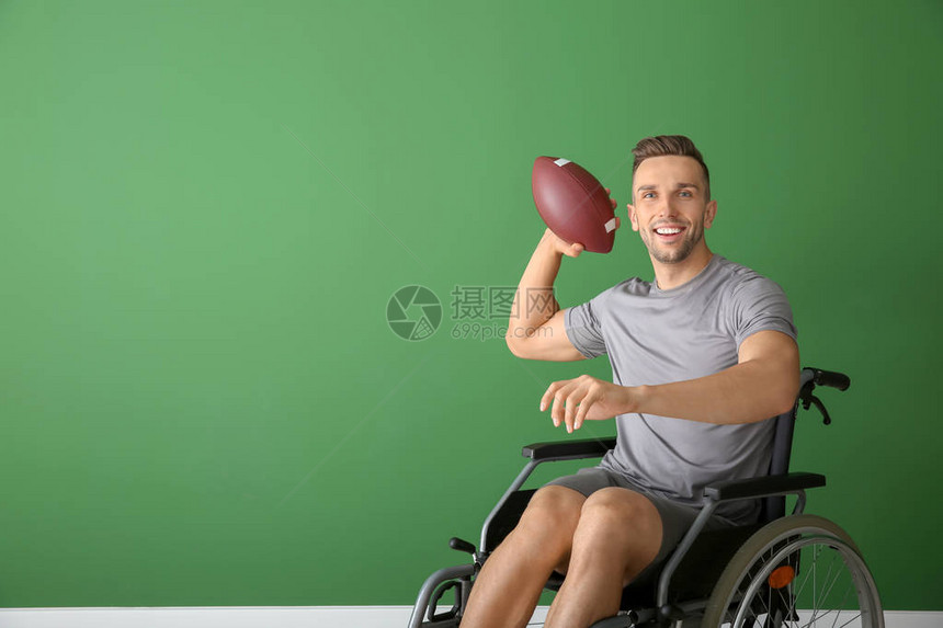 带着橄榄球的年轻人坐在轮椅上图片