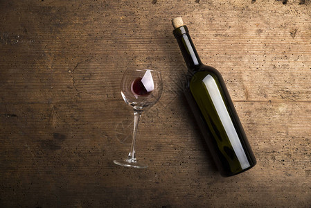 红葡萄酒杯和石头背景的瓶子带有复制空图片