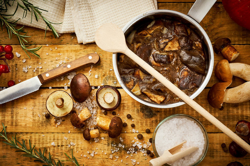 美味的棕色蘑菇煮在酸奶油里在木制桌图片