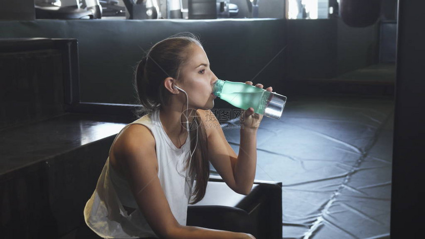 年轻感美丽的女人在运动服后休息听音乐喝水化保健身体护理运动积极的生活方式能量敏捷图片