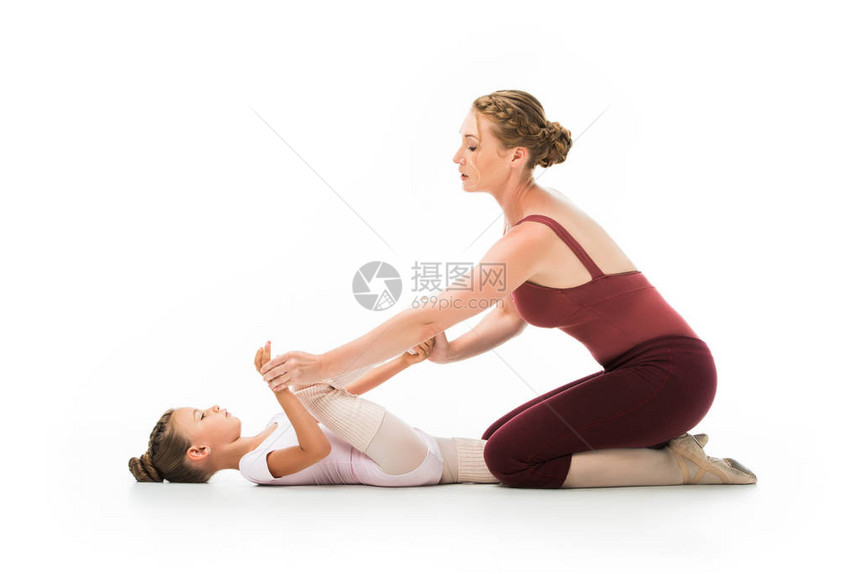 自信的女训练员帮助小芭蕾舞女教练在白色背图片