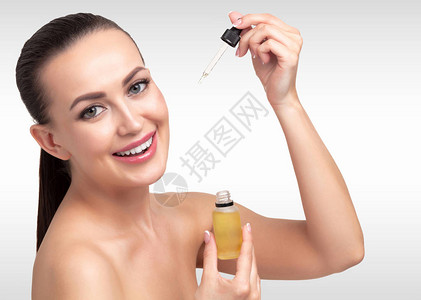 美容油贴在年轻女人脸上用管子涂上美背景图片