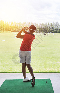 年轻的高尔夫球手在高尔夫球场院子标志的练习图片
